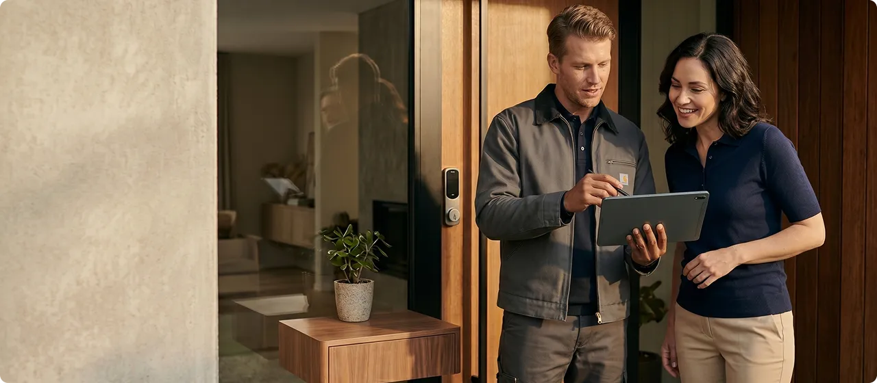 Brisbane locksmith technician reviewing a smart lock installation with a homeowner at her front door